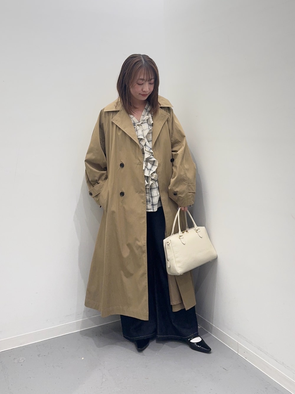 ベージュ系のその他アウター、ブラック系のシャツ/ブラウス、ブルー系のデニムパンツを着用したレディースの春コーディネートの2枚目の写真