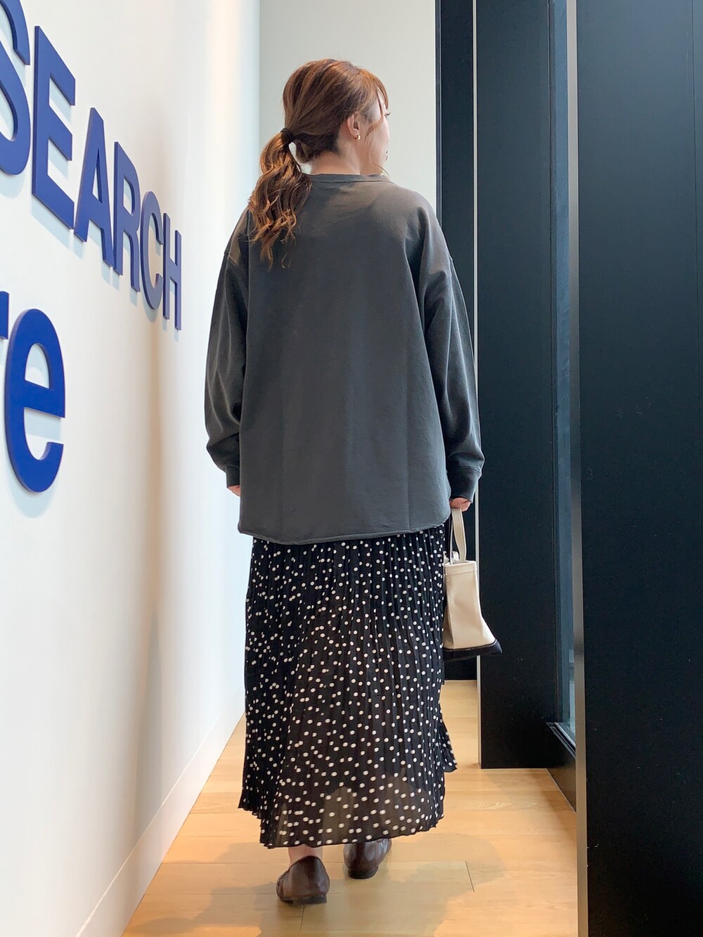 ブラック系のTシャツ/カットソー、ブラック系のスカート、ブラウン系のローファーを着用したレディースの冬コーディネートの3枚目の写真