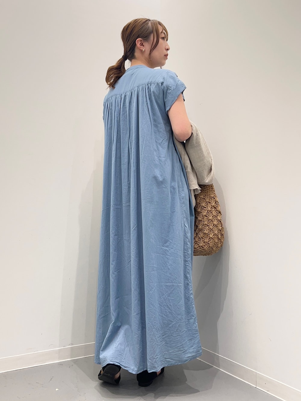 ブルー系のワンピース、ベージュ系のかごバッグ、ベージュ系のカーディガン/ボレロを着用したレディースの春コーディネートの4枚目の写真