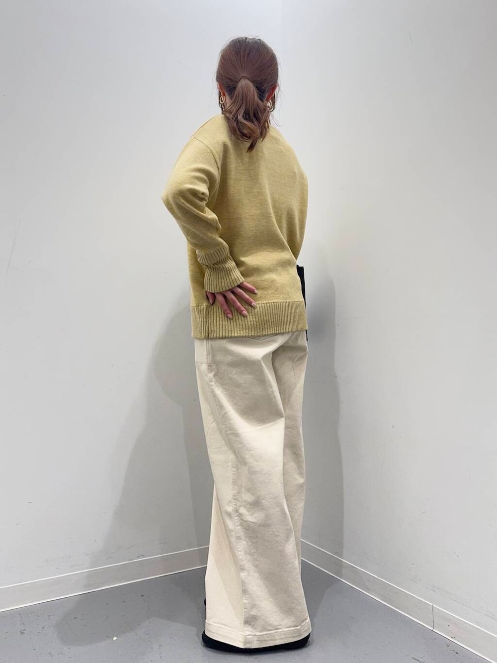 ブラック系のローファー、ブラック系のトートバッグ、イエロー系のニット/セーターを着用したレディースの冬コーディネートの2枚目の写真