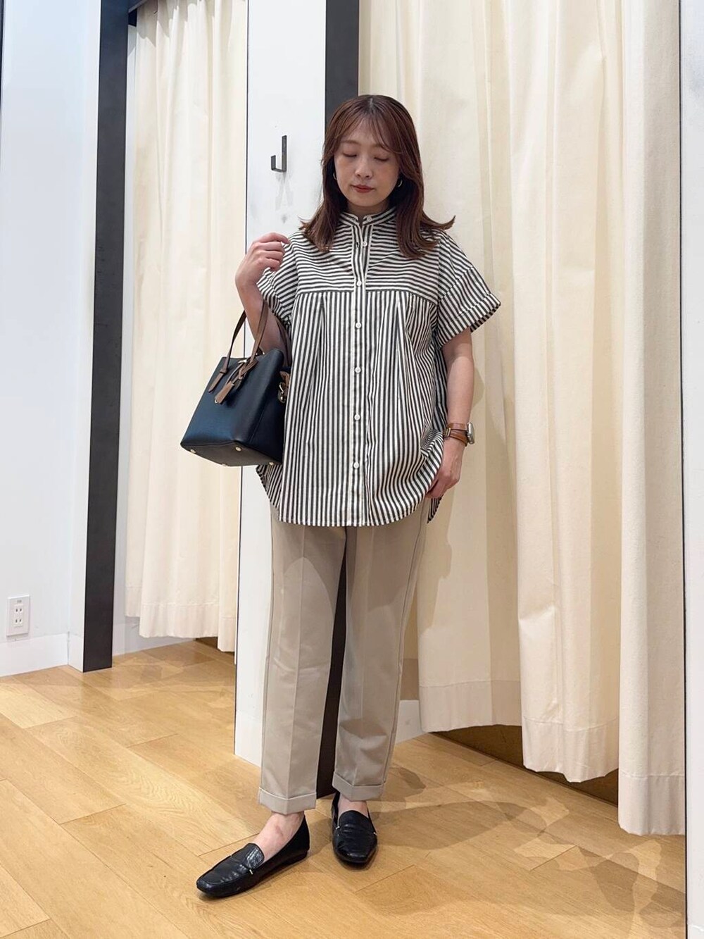 ブラック系のローファー、ブラック系のトートバッグ、ベージュ系のその他パンツを着用したレディースの夏コーディネートの5枚目の写真