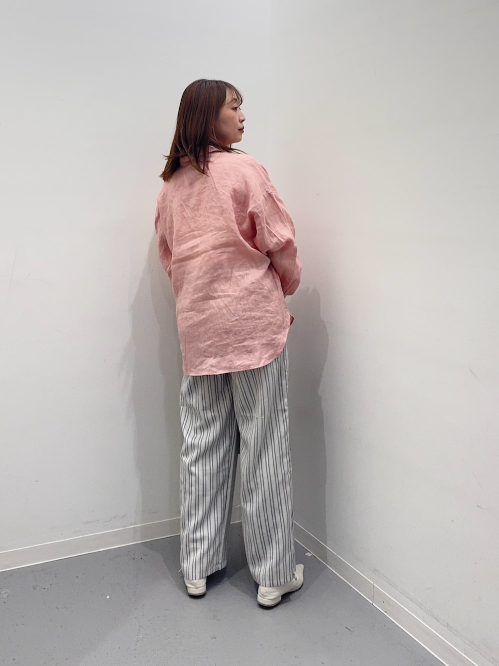 ピンク系のシャツ/ブラウス、グレー系のその他パンツ、ホワイト系のトートバッグを着用したレディースの春コーディネートの3枚目の写真