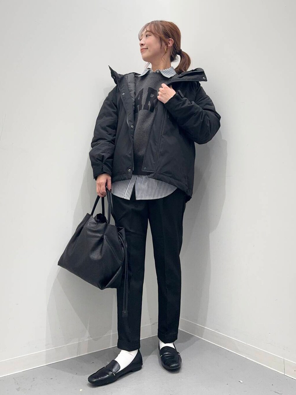 ブラック系のローファー、ブラック系のショルダーバッグ、ブルー系のシャツ/ブラウスを着用したレディースの冬コーディネートの2枚目の写真