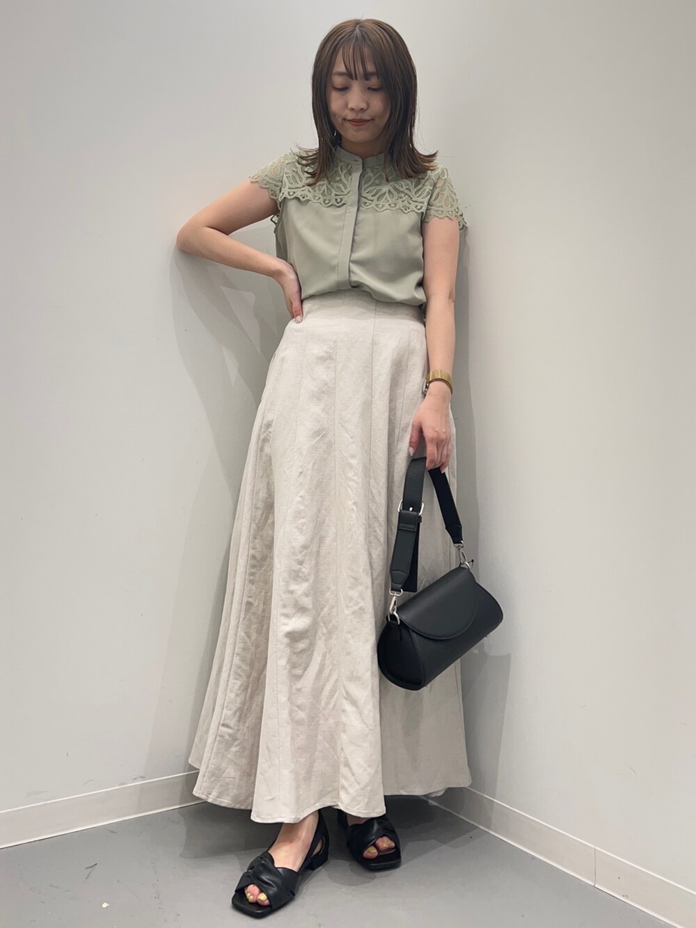 ホワイト系のスカート、グリーン系のシャツ/ブラウス、ブラック系のパンプスを着用したレディースの春コーディネートの2枚目の写真