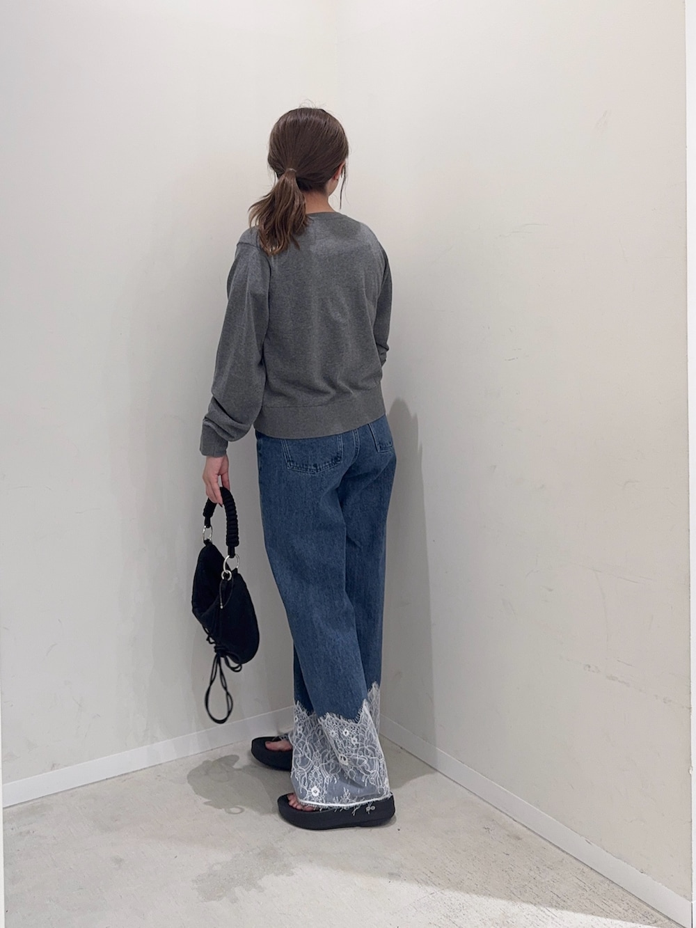グレー系のカーディガン/ボレロ、ブルー系のデニムパンツ、ブラック系のハンドバッグを着用したレディースの夏コーディネートの3枚目の写真