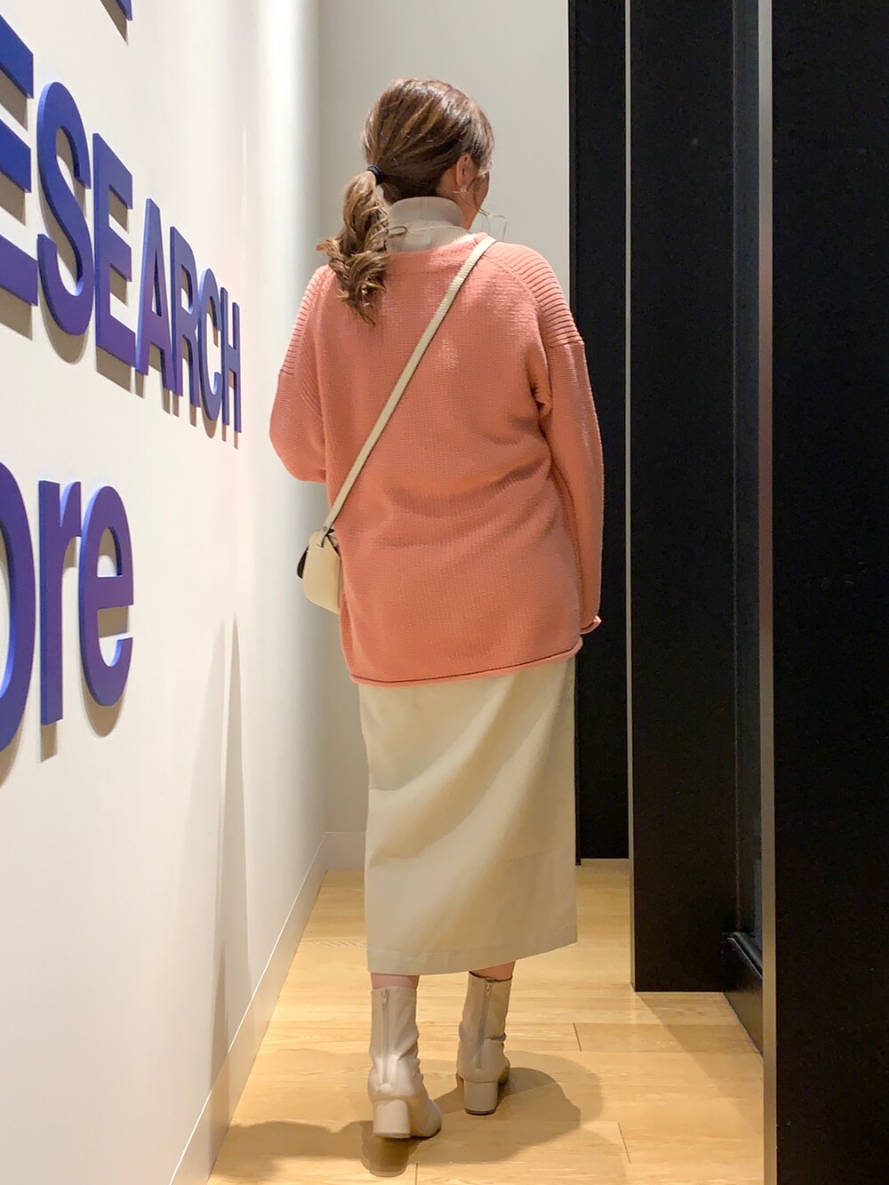 ピンク系のカーディガン/ボレロ、グレー系のニット/セーター、ベージュ系のスカートを着用したレディースの冬コーディネートの3枚目の写真