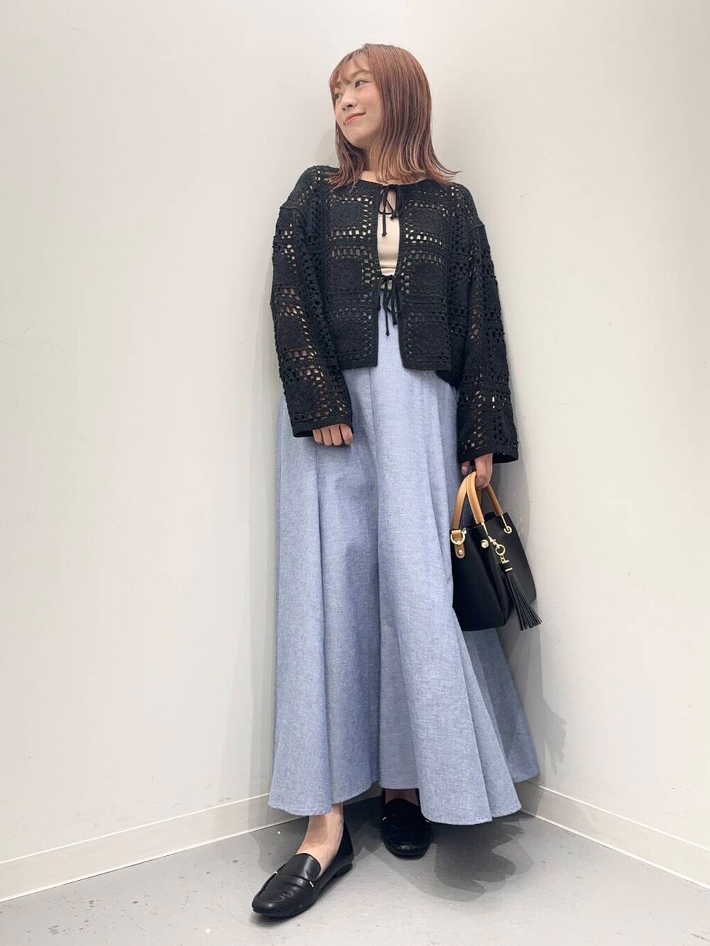 ブラック系のローファー、ブラック系のトートバッグ、ブルー系のスカートを着用したレディースの夏コーディネートの5枚目の写真