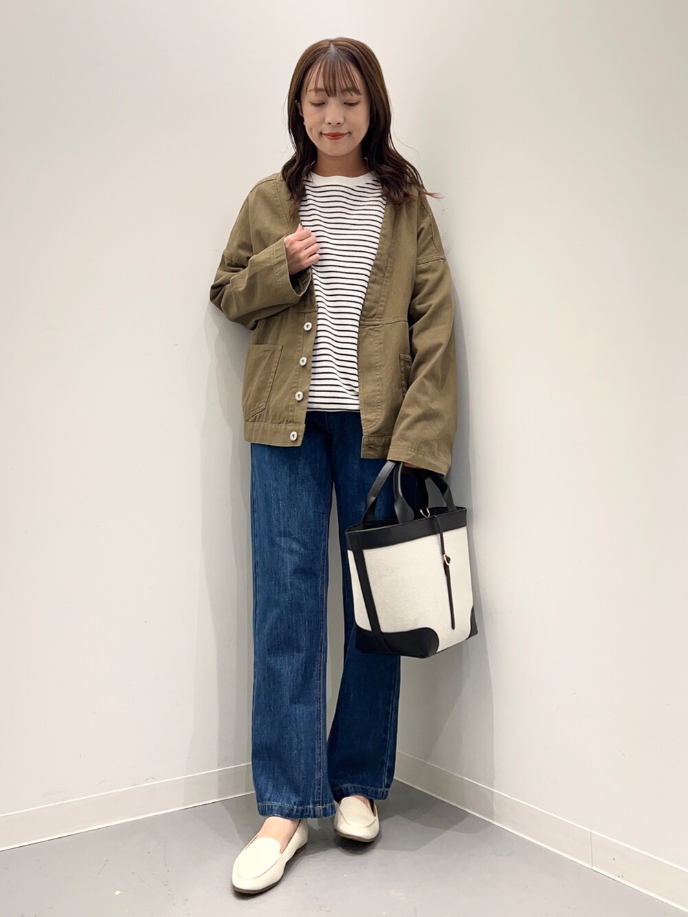 ブルー系のデニムパンツ、グリーン系のその他アウター、ホワイト系のTシャツ/カットソーを着用したレディースの秋コーディネートの5枚目の写真