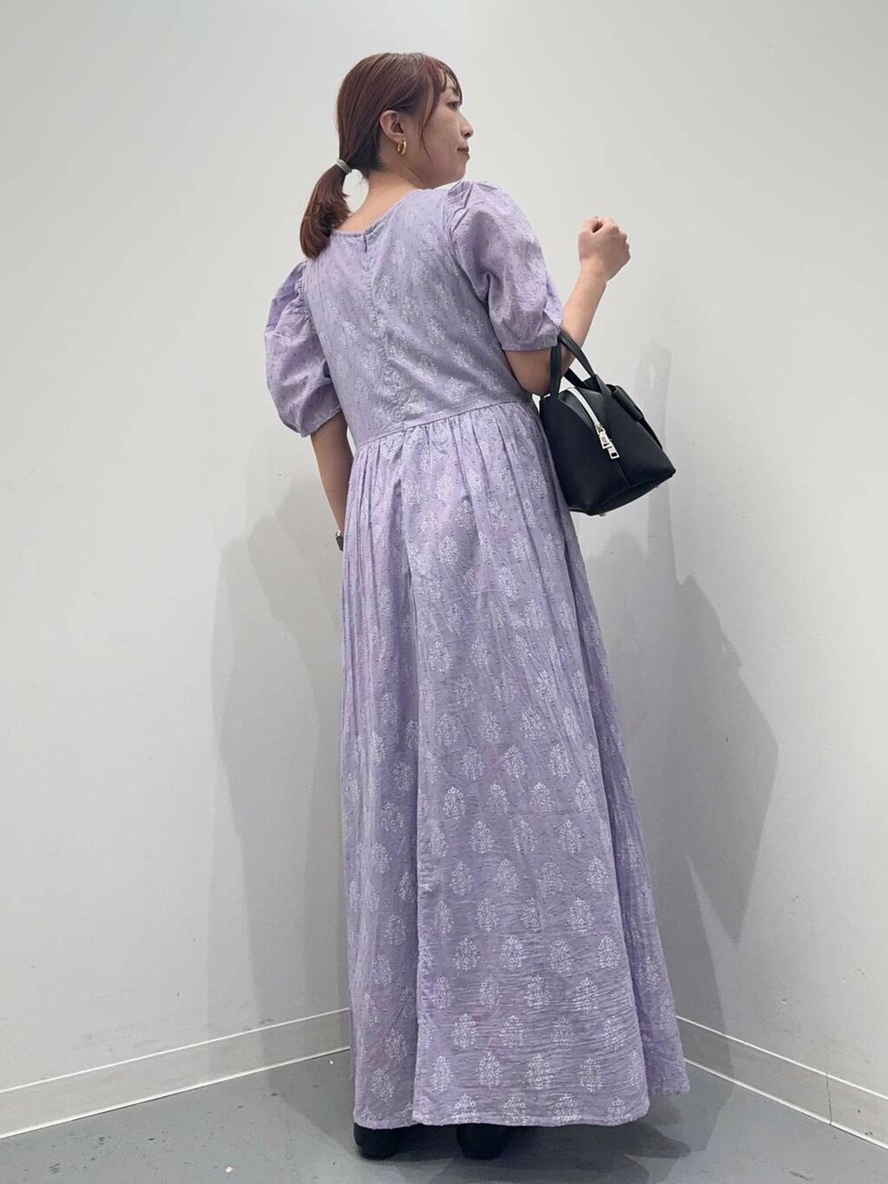 ブラック系のローファー、ブラック系のボストンバッグ、パープル系のワンピースを着用したレディースの夏コーディネートの4枚目の写真