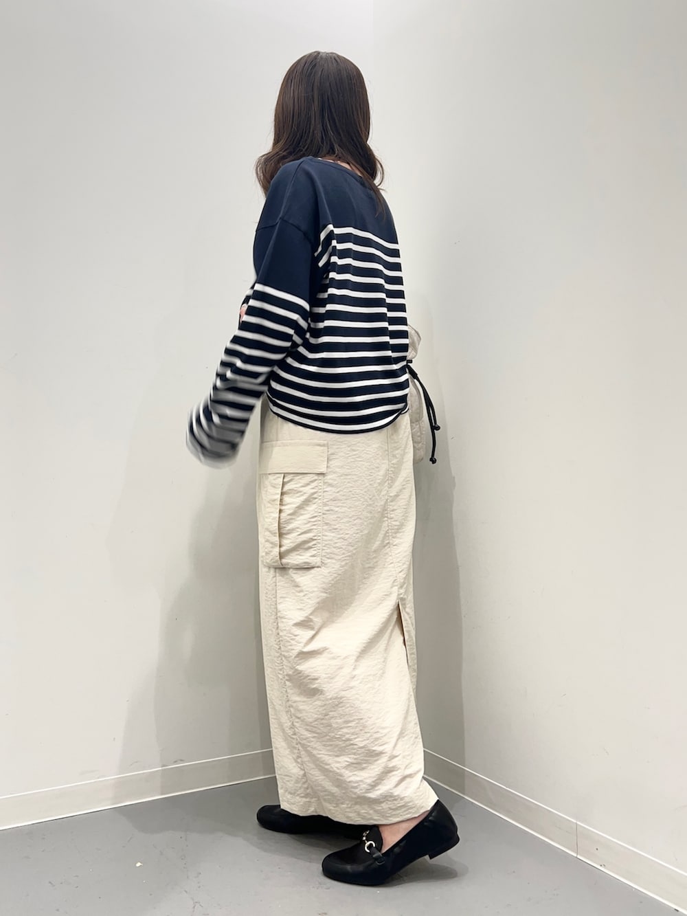 ホワイト系のスカート、ブルー系のTシャツ/カットソー、ブラック系のローファーを着用したレディースの夏コーディネートの3枚目の写真