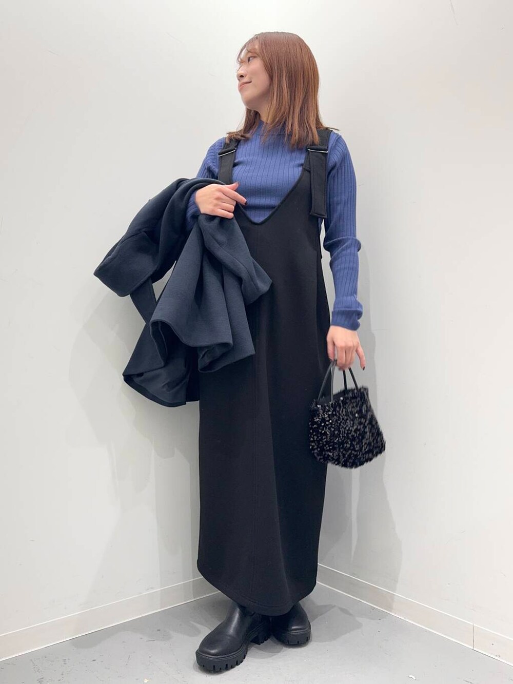 ブラック系のショルダーバッグ、ブラック系のブーツ、ブルー系のステンカラーコートを着用したレディースの冬コーディネートの6枚目の写真