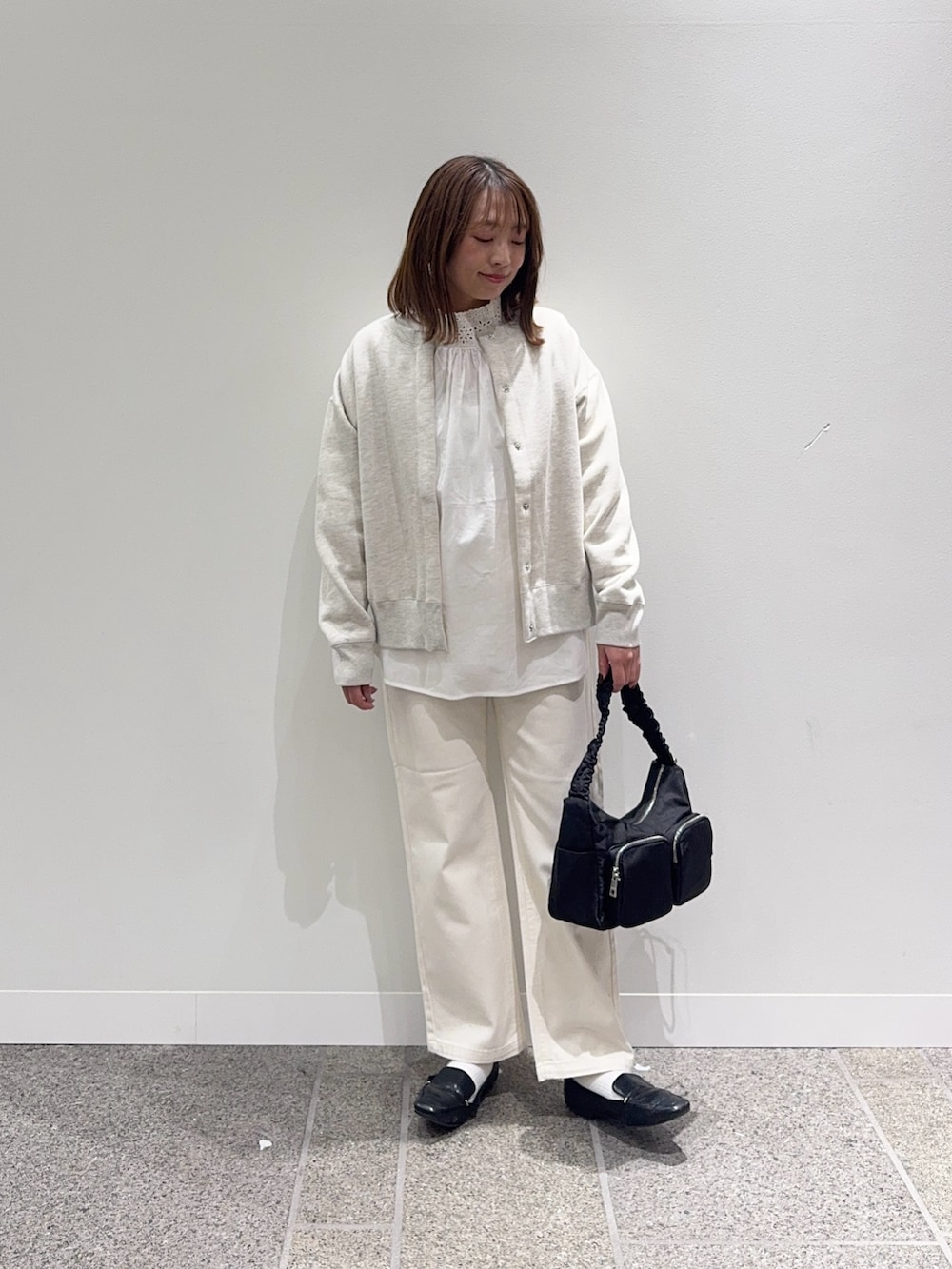 ホワイト系のシャツ/ブラウス、ベージュ系のカーディガン/ボレロ、ベージュ系のデニムパンツを着用したレディースの冬コーディネートの2枚目の写真