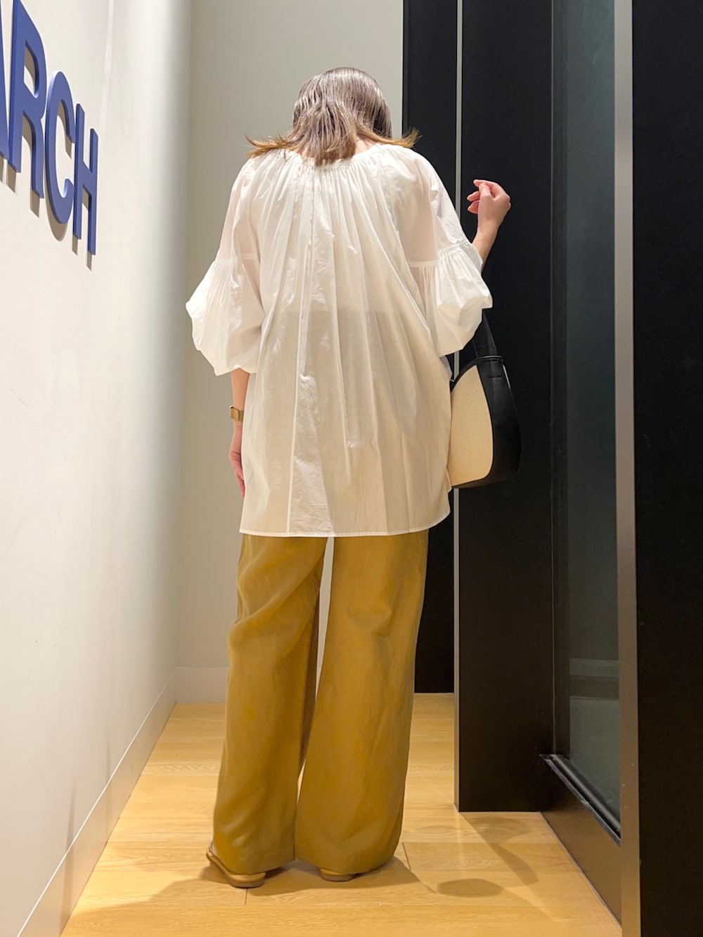 ホワイト系のシャツ/ブラウス、イエロー系のその他パンツ、ブラック系のハンドバッグを着用したレディースの夏コーディネートの4枚目の写真