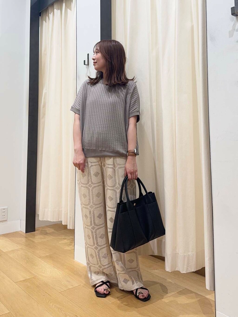 ブラック系のトートバッグ、ベージュ系のその他パンツ、ブラック系のサンダルを着用したレディースの夏コーディネートの4枚目の写真
