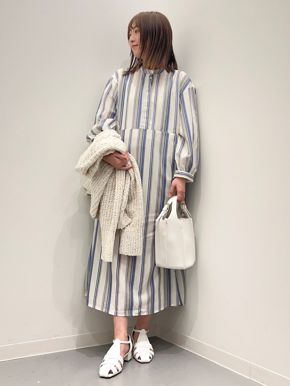 ホワイト系のカーディガン/ボレロ、ホワイト系のサンダル、ブルー系のワンピースを着用したレディースの春コーディネートの6枚目の写真