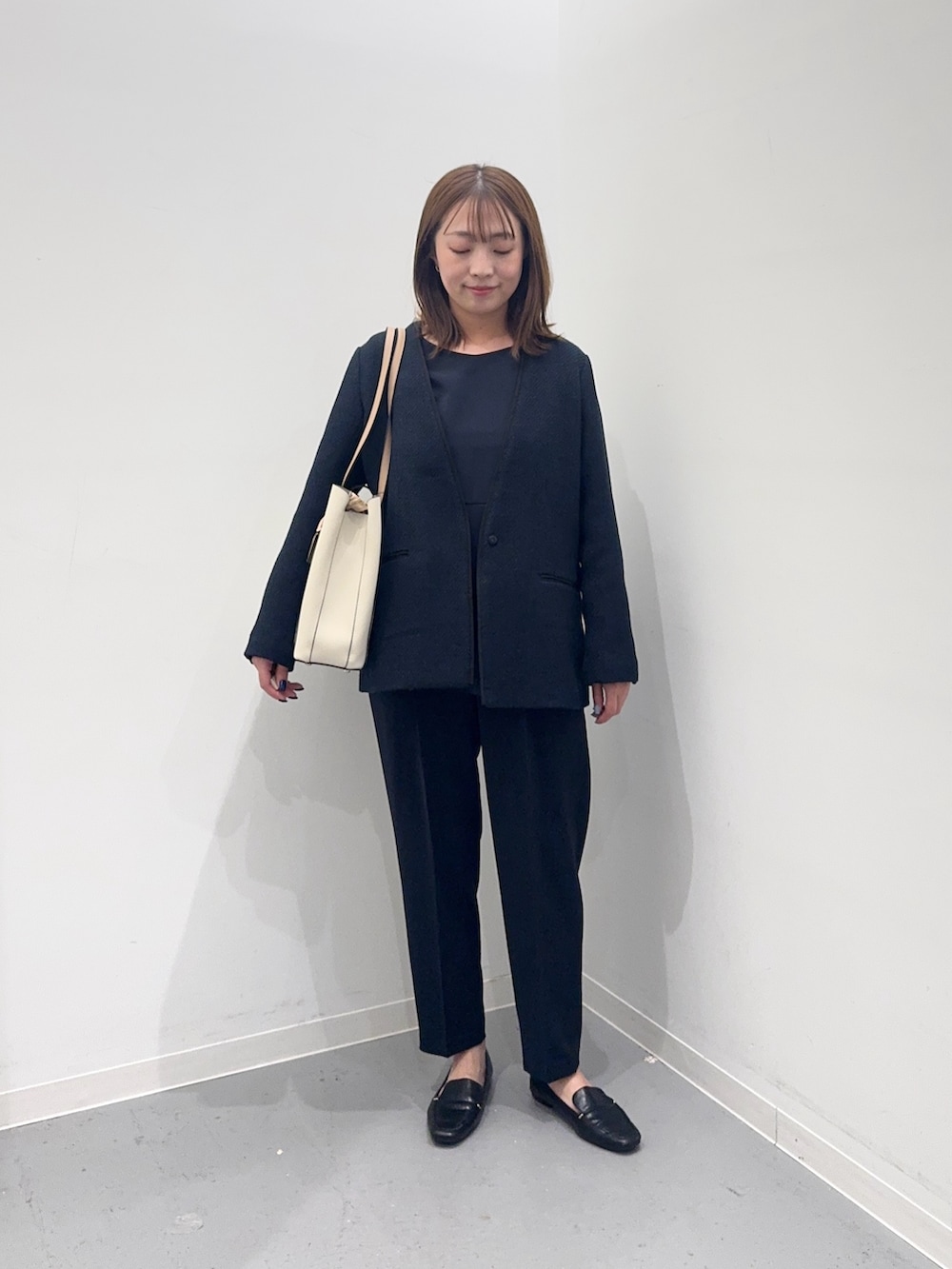 ブルー系のセットアップ、ブルー系のスーツジャケット、ホワイト系のトートバッグを着用したレディースの冬コーディネートの2枚目の写真