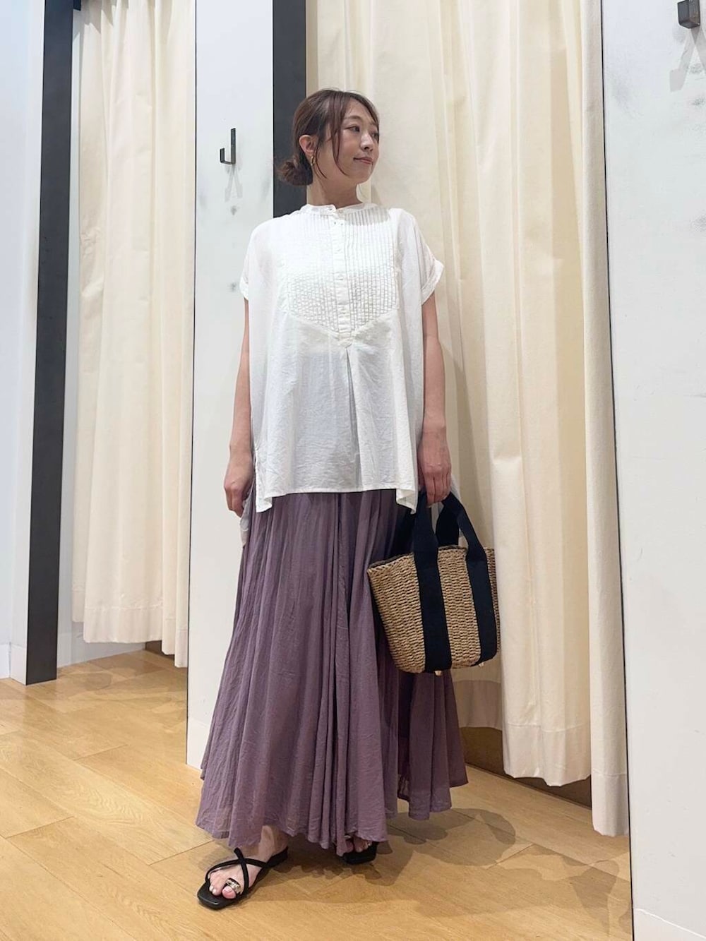 ベージュ系のハンドバッグ、ホワイト系のTシャツ/カットソー、パープル系のスカートを着用したレディースの夏コーディネートの2枚目の写真