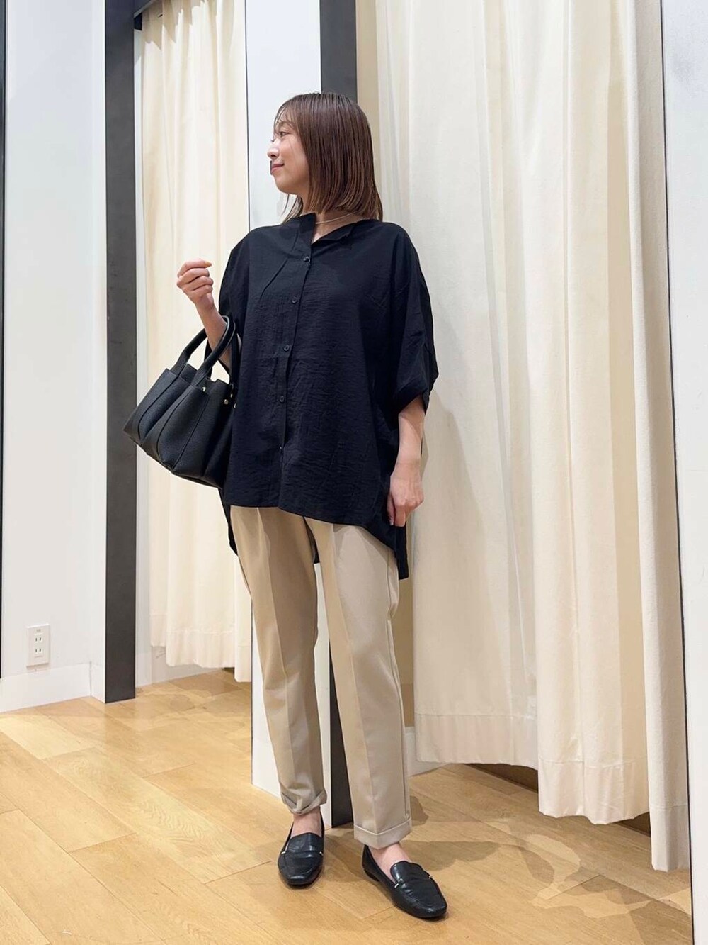 ブラック系のトートバッグ、ベージュ系のその他パンツ、ブラック系のシャツ/ブラウスを着用したレディースの夏コーディネートの6枚目の写真