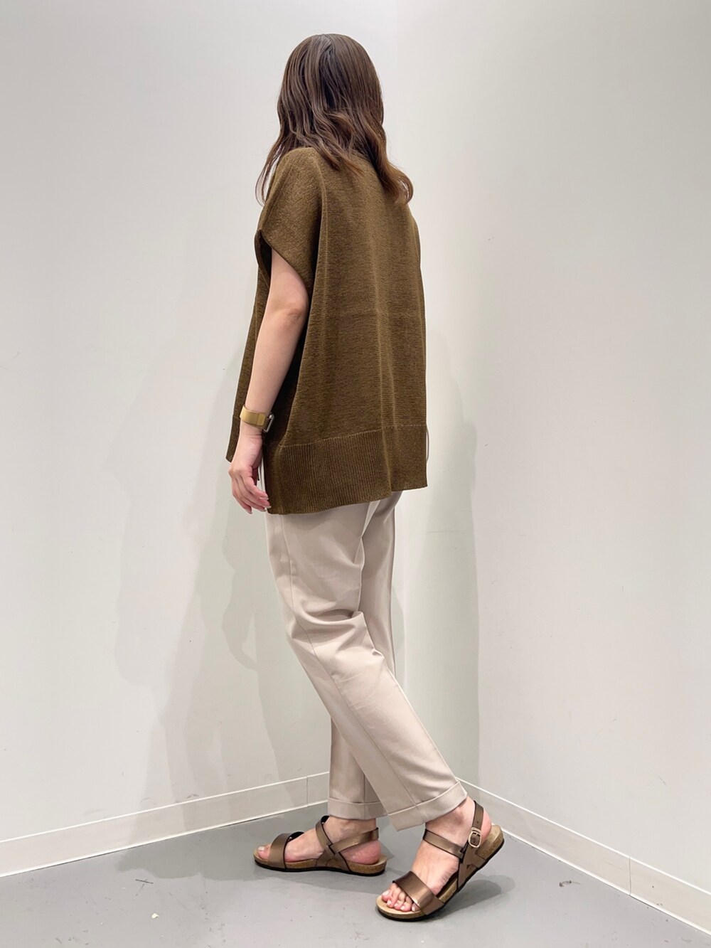 イエロー系のトップス、ベージュ系のその他パンツ、ブラウン系のサンダルを着用したレディースの夏コーディネートの3枚目の写真