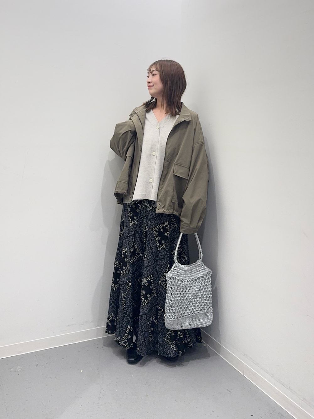 ベージュ系のカーディガン/ボレロ、グリーン系のブルゾン、ブラック系のスカートを着用したレディースの春コーディネートの4枚目の写真