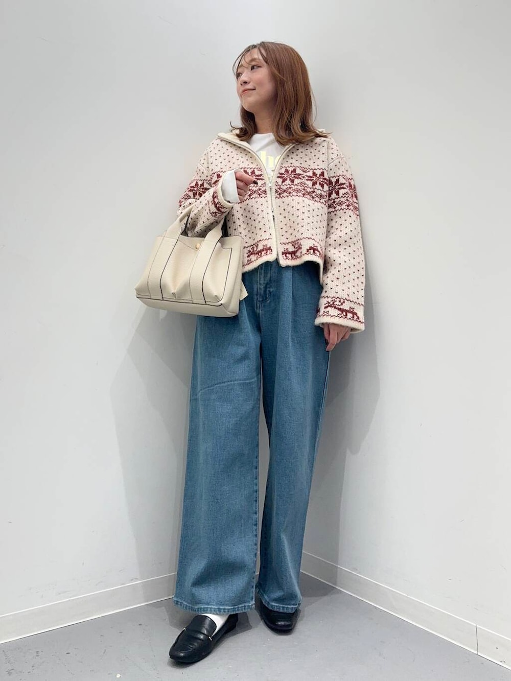 ブラック系のローファー、ホワイト系のトートバッグ、レッド系のニット/セーターを着用したレディースの秋コーディネートの2枚目の写真