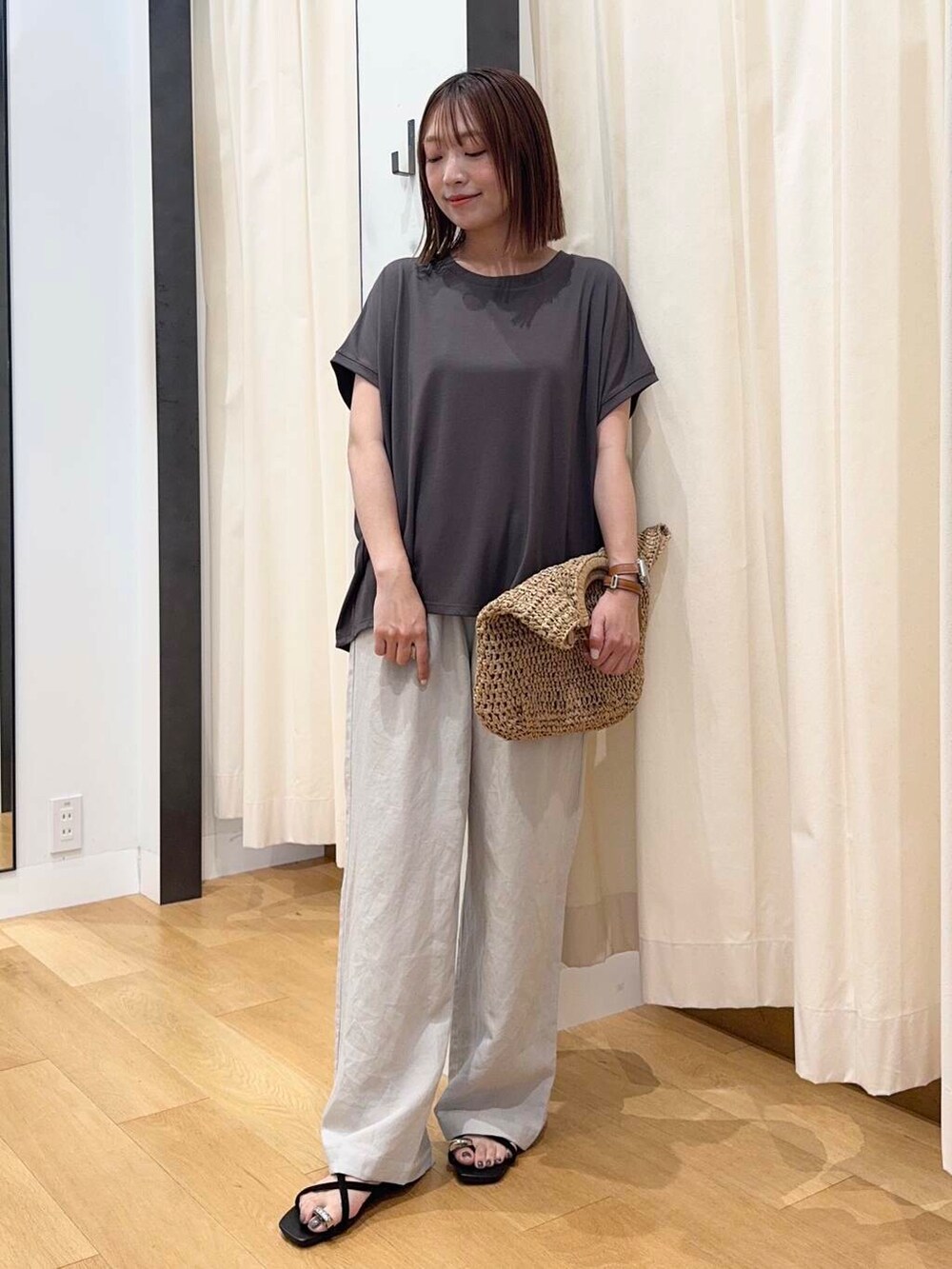 ベージュ系のトートバッグ、グレー系のTシャツ/カットソー、ベージュ系のその他パンツを着用したレディースの夏コーディネートの2枚目の写真