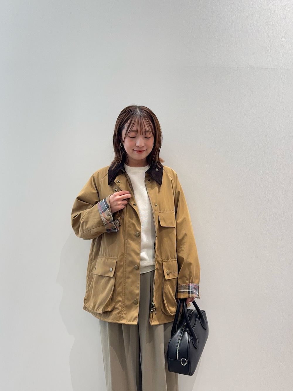 ベージュ系のその他アウター、ブラック系のショルダーバッグ、ベージュ系のスニーカーを着用したレディースの秋コーディネートの5枚目の写真
