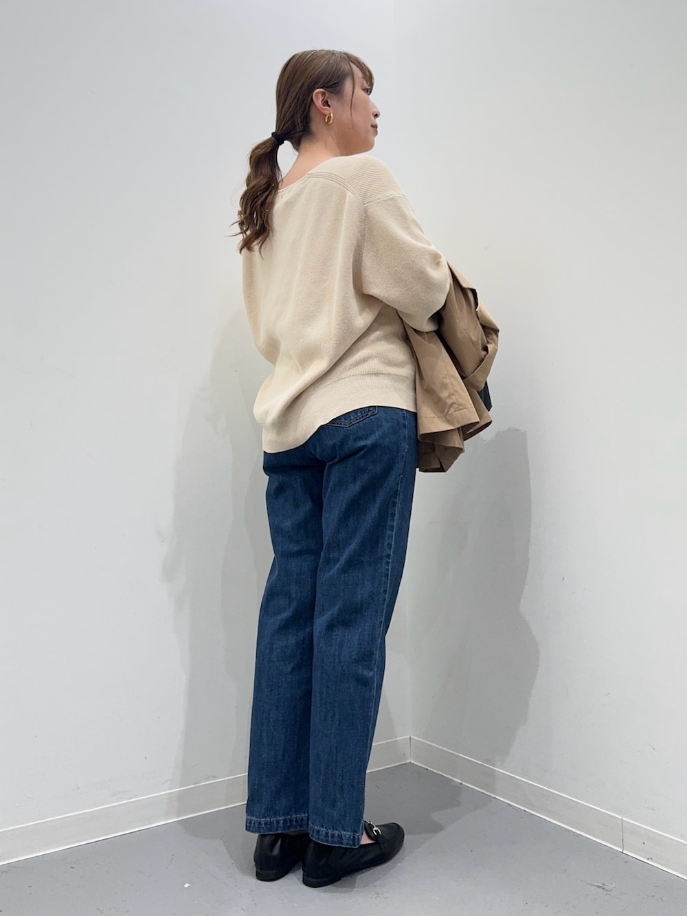 ホワイト系のニット/セーター、ベージュ系のその他アウター、ブルー系のデニムパンツを着用したレディースの春コーディネートの3枚目の写真