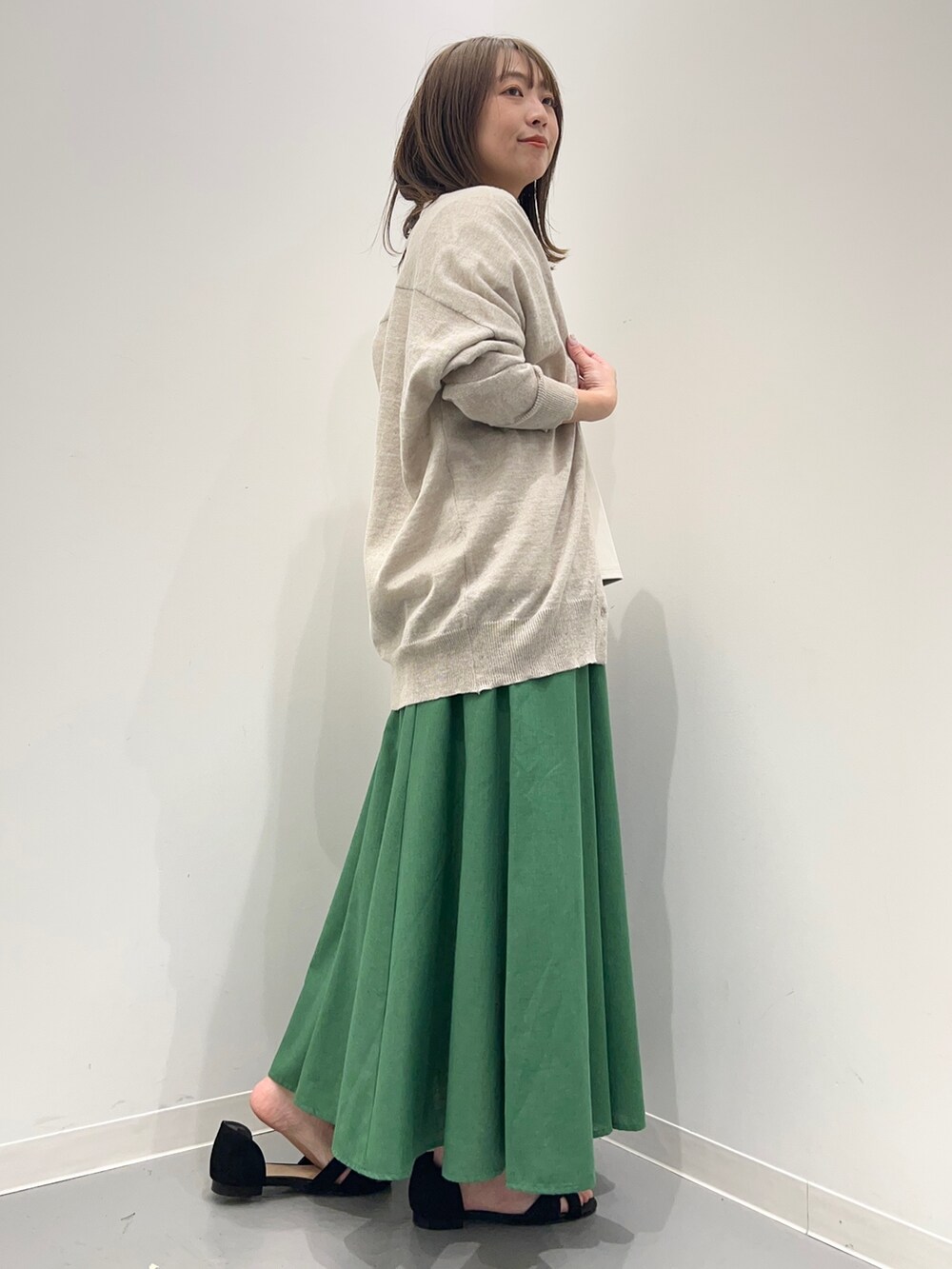 グレー系のTシャツ/カットソー、ブラック系のサンダル、グリーン系のスカートを着用したレディースの春コーディネートの7枚目の写真