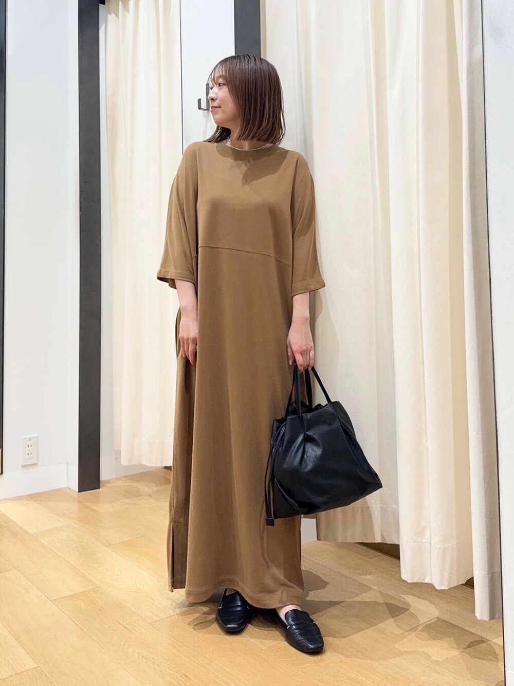 ブラック系のショルダーバッグ、ブラック系のローファー、イエロー系のワンピースを着用したレディースの夏コーディネートの2枚目の写真