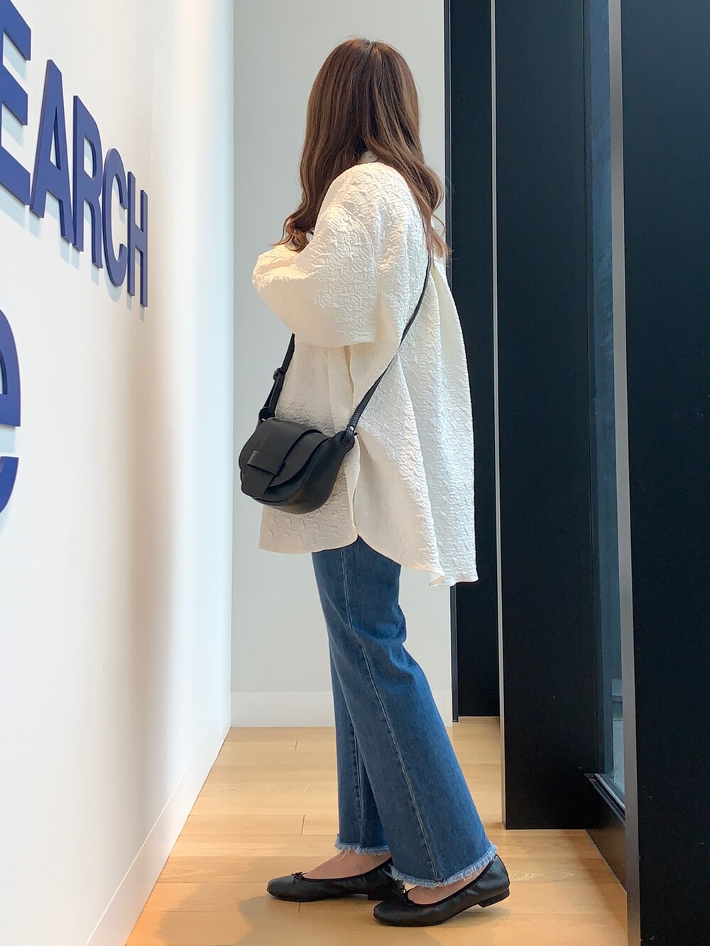 ホワイト系のシャツ/ブラウス、ブルー系のデニムパンツ、ブラック系のバレエシューズを着用したレディースの冬コーディネートの3枚目の写真