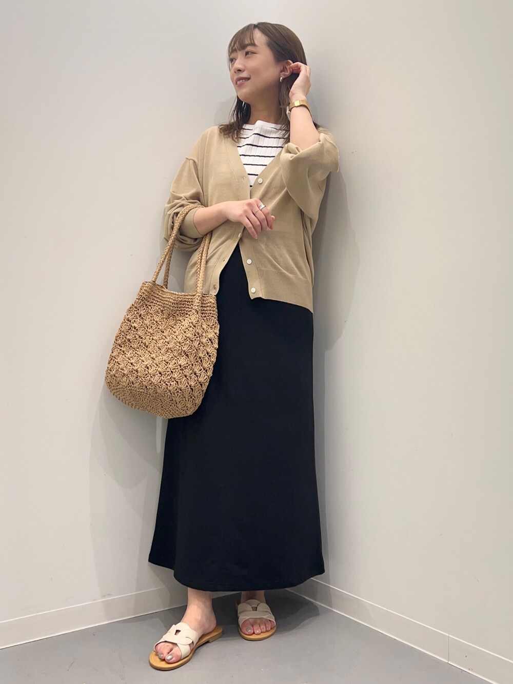 ホワイト系のTシャツ/カットソー、ベージュ系のカーディガン/ボレロ、ブラック系のスカートを着用したレディースの夏コーディネートの2枚目の写真