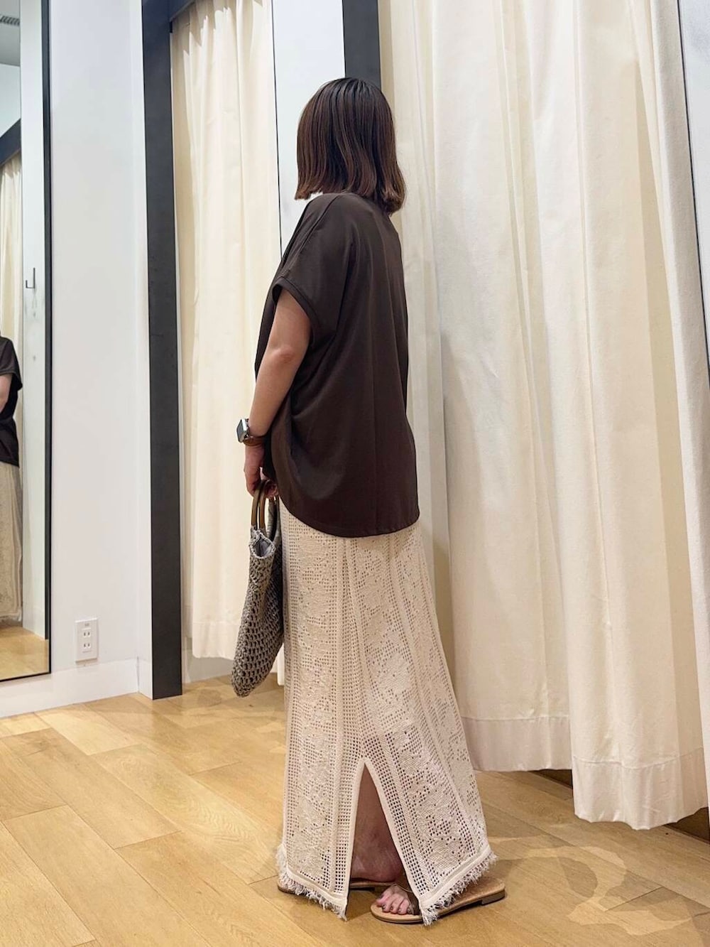 ブラウン系のサンダル、グレー系のトートバッグ、ホワイト系のスカートを着用したレディースの夏コーディネートの3枚目の写真