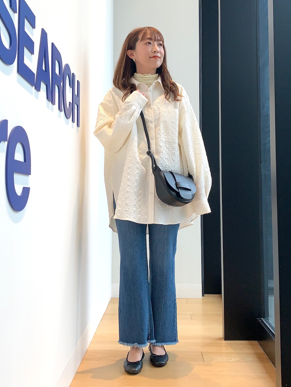 ホワイト系のシャツ/ブラウス、ブルー系のデニムパンツ、ブラック系のバレエシューズを着用したレディースの冬コーディネートの2枚目の写真