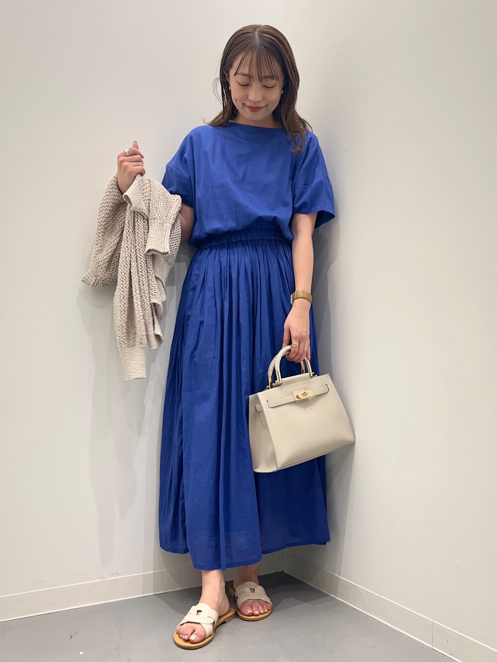 ブルー系のワンピース、ホワイト系のカーディガン/ボレロ、ホワイト系のハンドバッグを着用したレディースの夏コーディネートの7枚目の写真