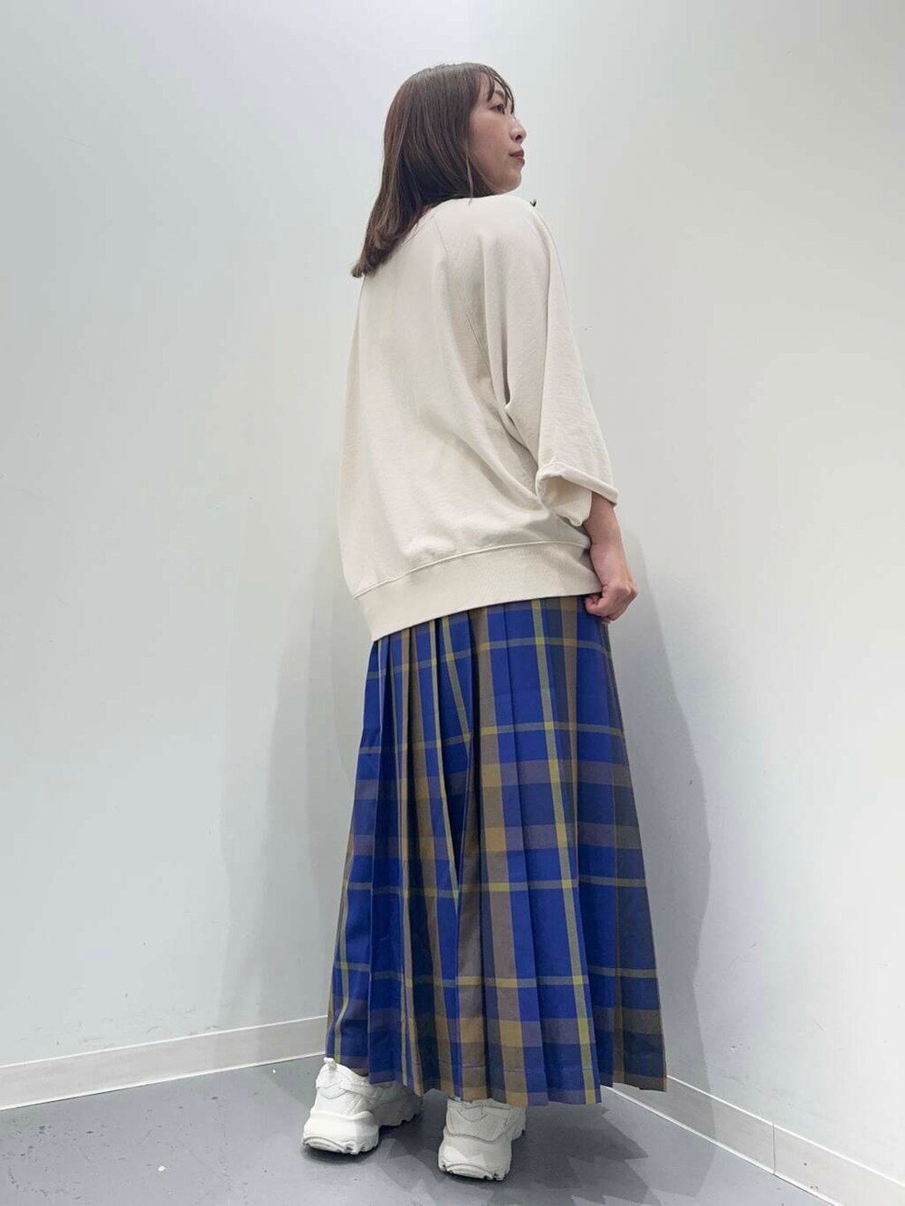 ベージュ系のTシャツ/カットソー、ブルー系のスカートを着用したレディースの秋コーディネートの3枚目の写真