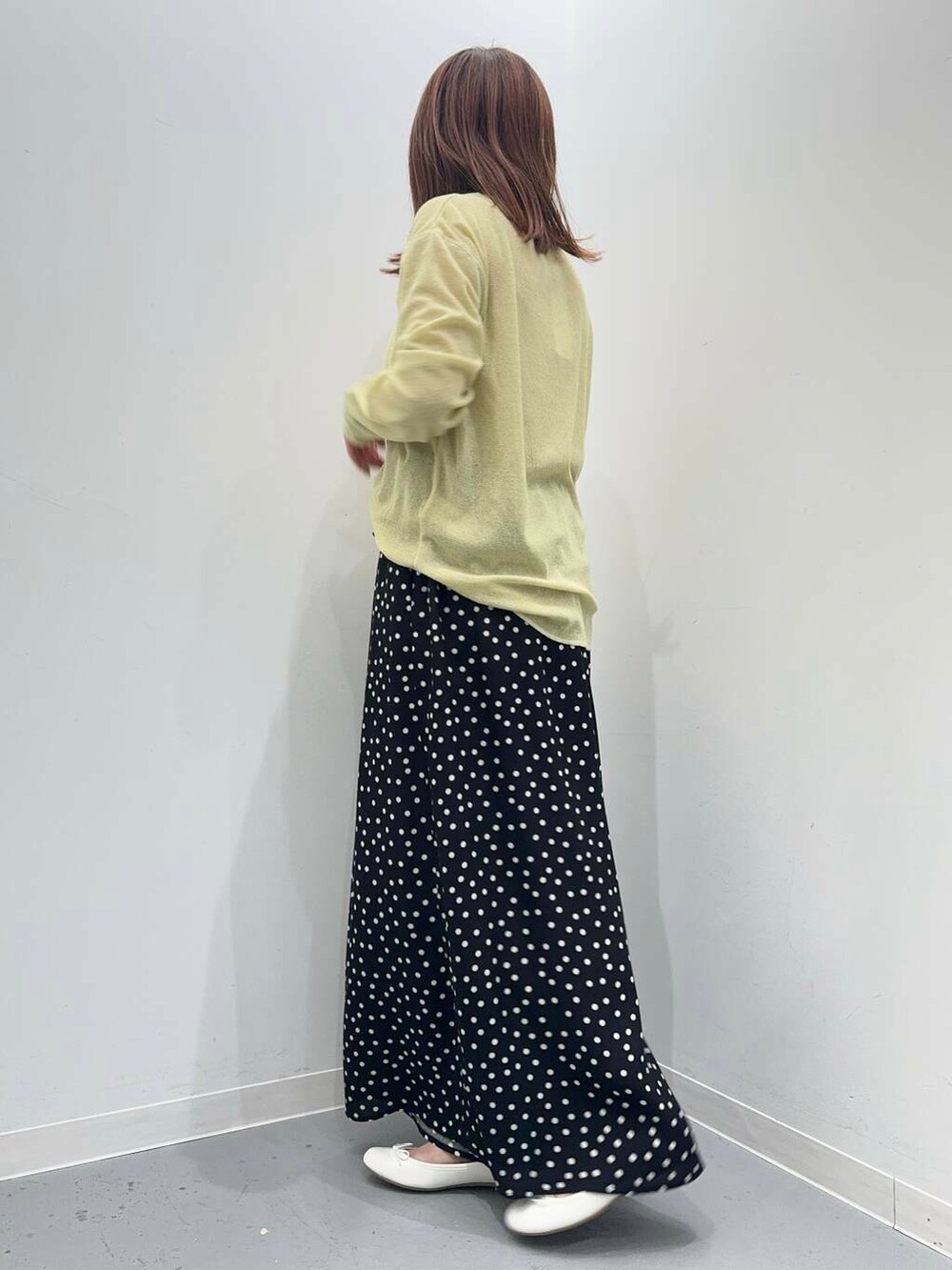 ホワイト系のトートバッグ、ホワイト系のバレエシューズ、イエロー系のTシャツ/カットソーを着用したレディースの夏コーディネートの3枚目の写真