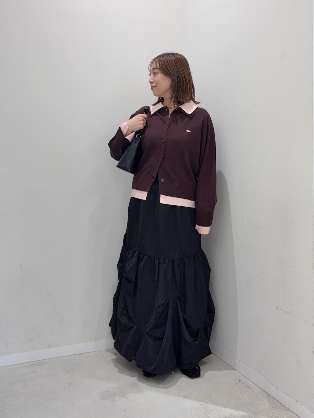 ブラウン系のカーディガン/ボレロ、ブラック系のスカート、ブラック系のパンプスを着用したレディースの秋コーディネートの4枚目の写真