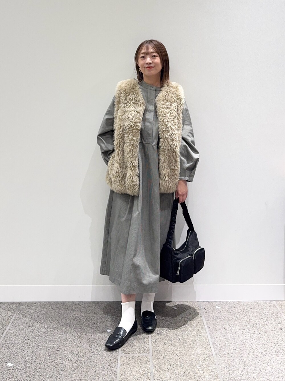 グレー系のワンピース、ベージュ系のその他アウター、ブラック系のショルダーバッグを着用したレディースの秋コーディネートの8枚目の写真