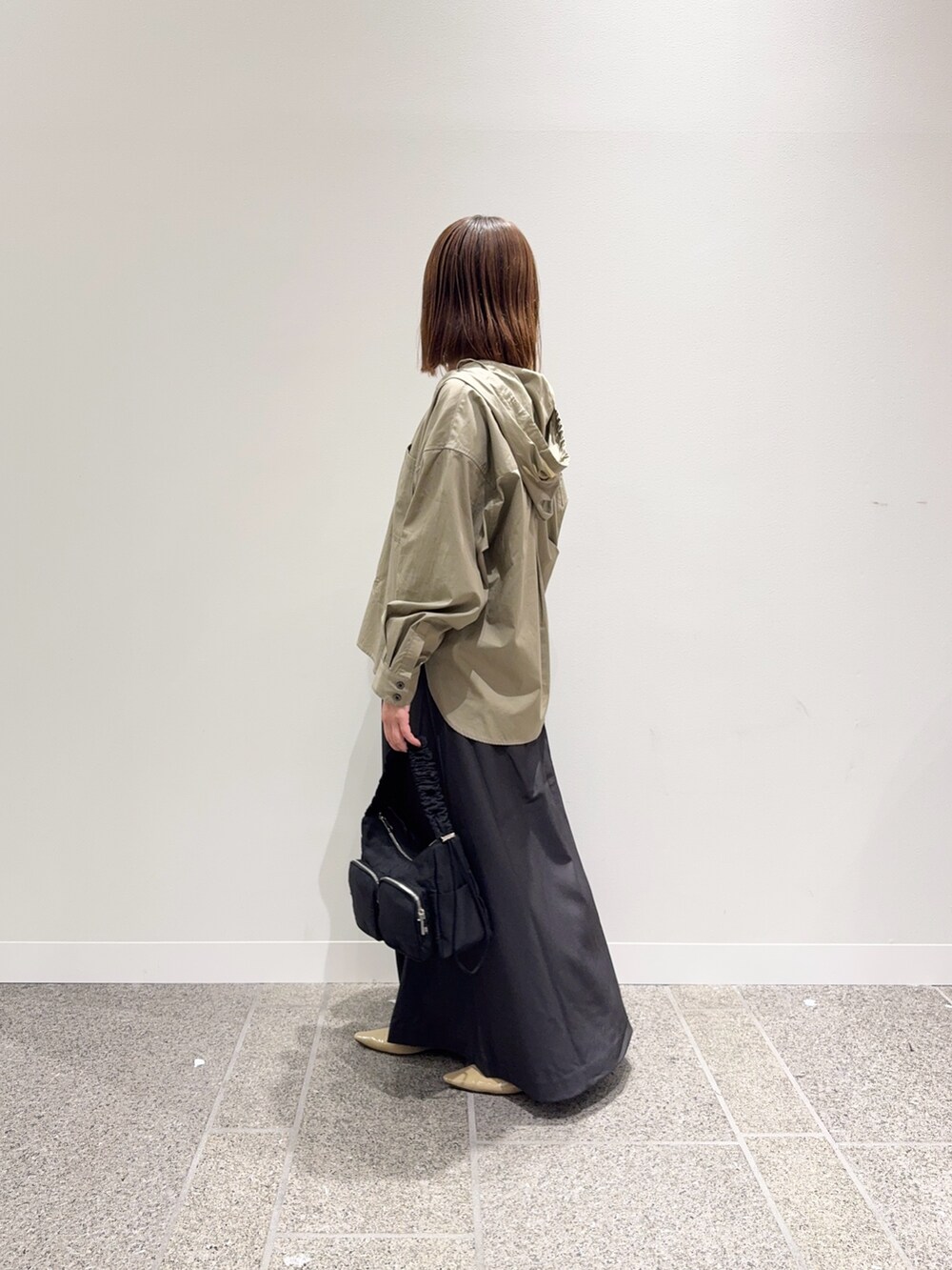 ベージュ系のシャツ/ブラウス、グレー系のスカート、ベージュ系のパンプスを着用したレディースの秋コーディネートの3枚目の写真