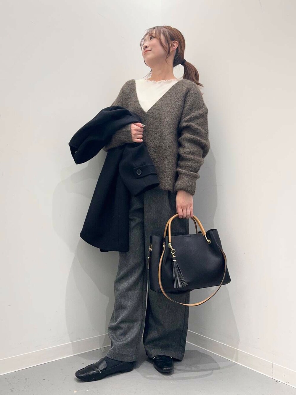 ブラック系のローファー、ブラック系のトートバッグ、ブラック系のその他アウターを着用したレディースの冬コーディネートの8枚目の写真
