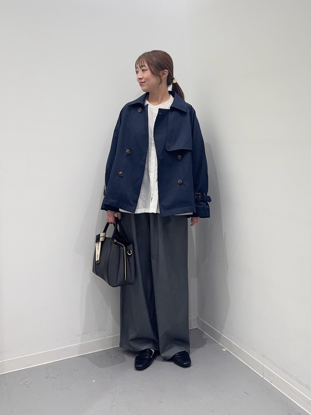 ブルー系のトレンチコート、ホワイト系のシャツ/ブラウス、グレー系のその他パンツを着用したレディースの春コーディネートの4枚目の写真
