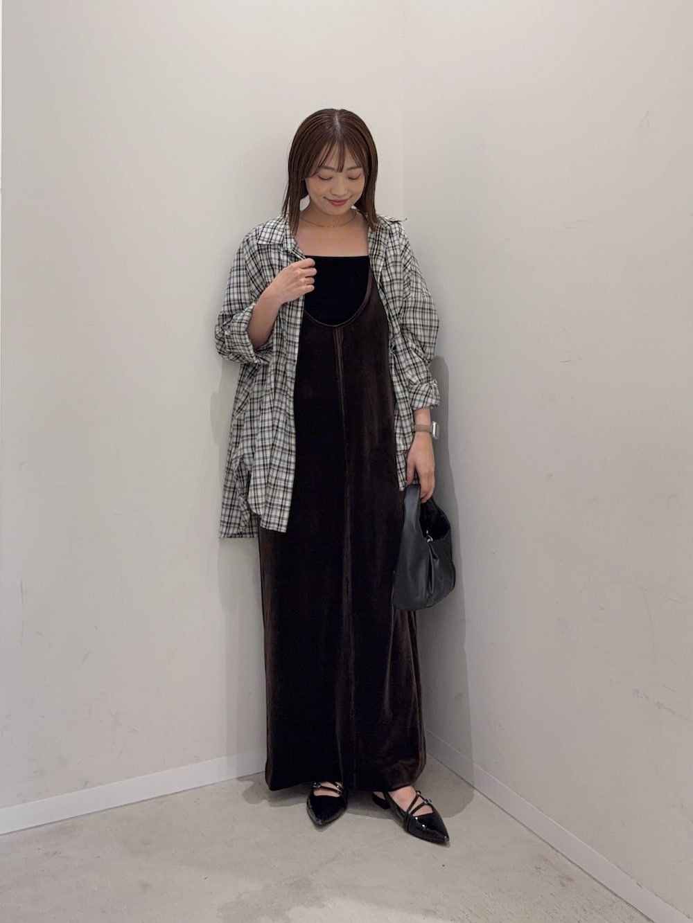 ホワイト系のシャツ/ブラウス、ブラウン系のワンピース、ブラック系のハンドバッグを着用したレディースの夏コーディネートの3枚目の写真