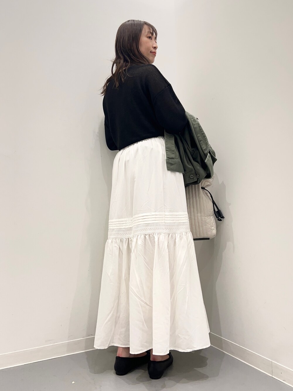 グリーン系のジャケット/アウター、ブラック系のニット/セーター、ホワイト系のスカートを着用したレディースの夏コーディネートの7枚目の写真