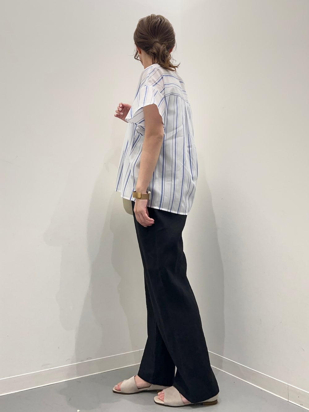 ブルー系のシャツ/ブラウス、ブラック系のその他パンツ、ベージュ系のハンドバッグを着用したレディースの春コーディネートの5枚目の写真