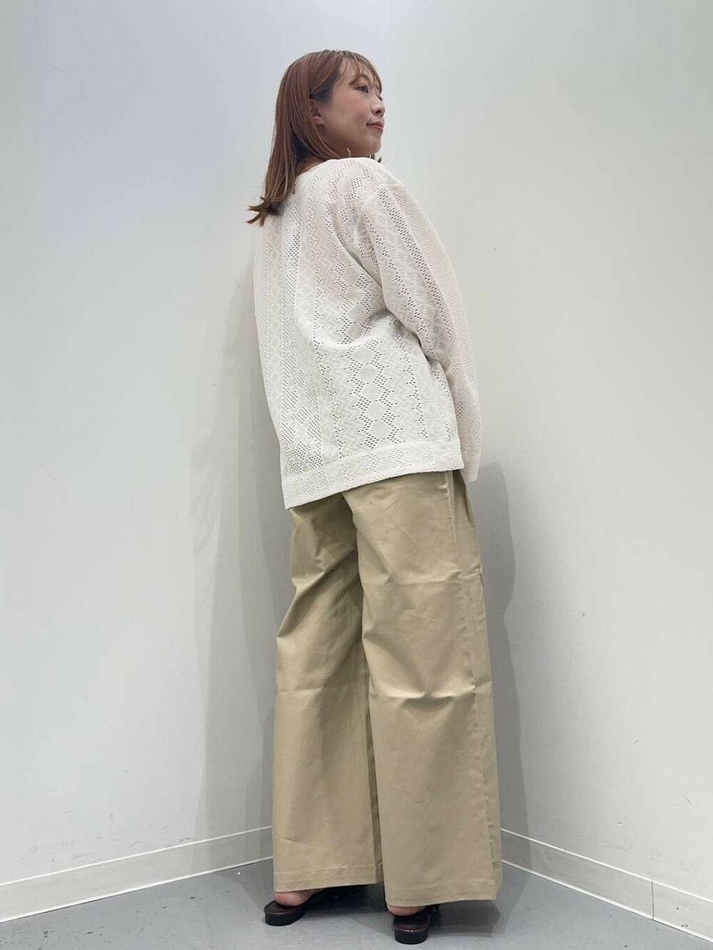 ブラウン系のハンドバッグ、ブラウン系のその他シューズ、ホワイト系のカーディガン/ボレロを着用したレディースの秋コーディネートの3枚目の写真