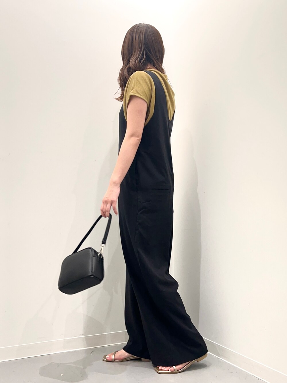 ブラック系のサロペット/オーバーオール、ゴールド系のサンダル、ブラック系のショルダーバッグを着用したレディースの夏コーディネートの4枚目の写真