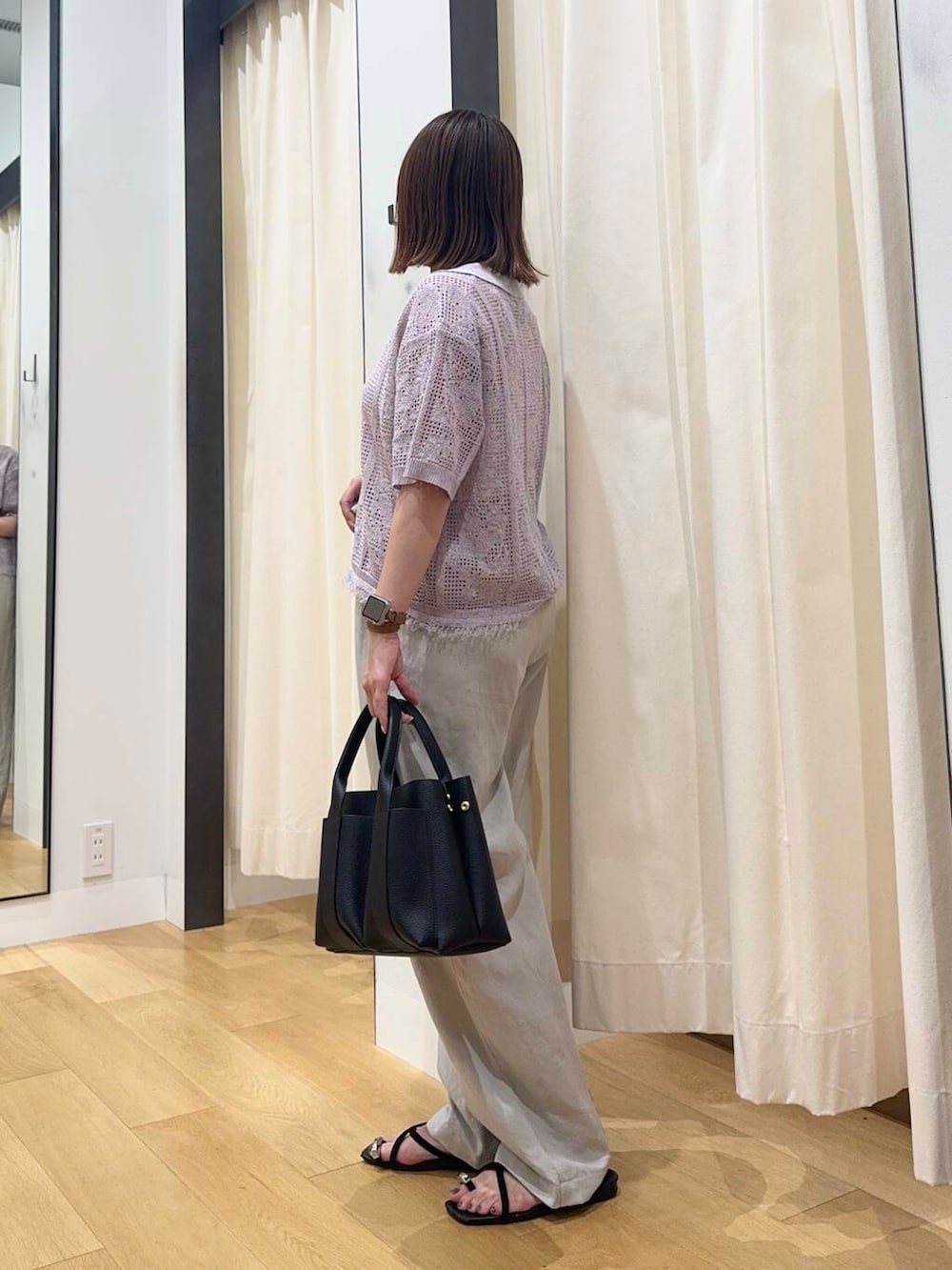 ホワイト系のトートバッグ、ベージュ系のその他パンツ、ブラック系のサンダルを着用したレディースの夏コーディネートの3枚目の写真