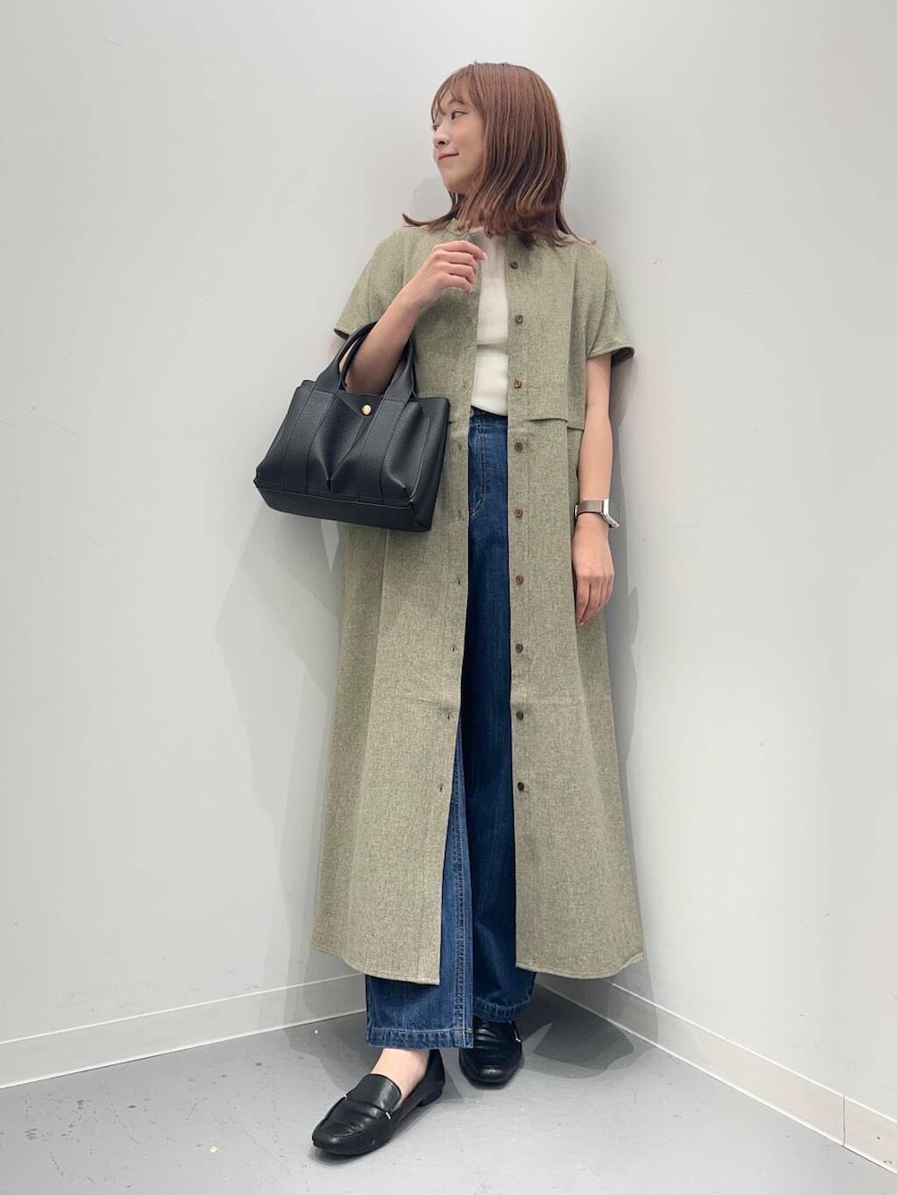 ブラック系のローファー、ブラック系のトートバッグ、ブルー系のデニムパンツを着用したレディースの夏コーディネートの2枚目の写真