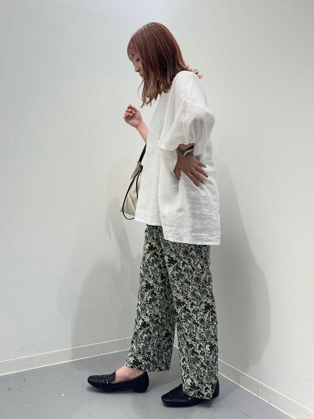 ブラック系のローファー、ホワイト系のシャツ/ブラウス、ホワイト系のショルダーバッグを着用したレディースの夏コーディネートの2枚目の写真